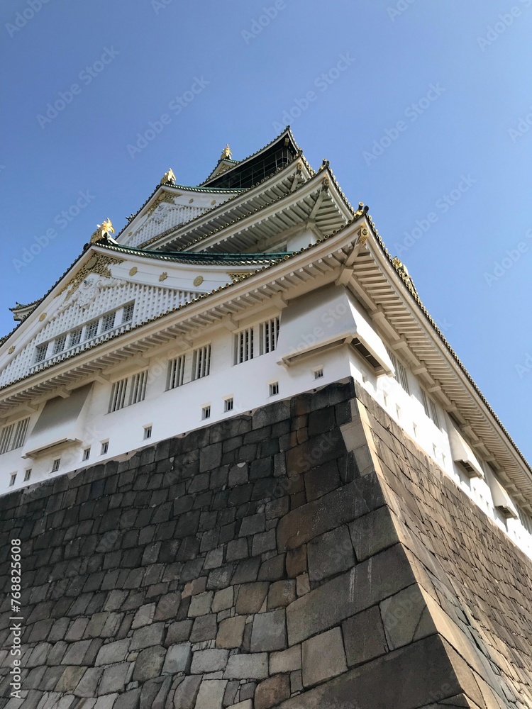 Low-angle shot of Osaka Castle against the background of a blue sky. Japan.