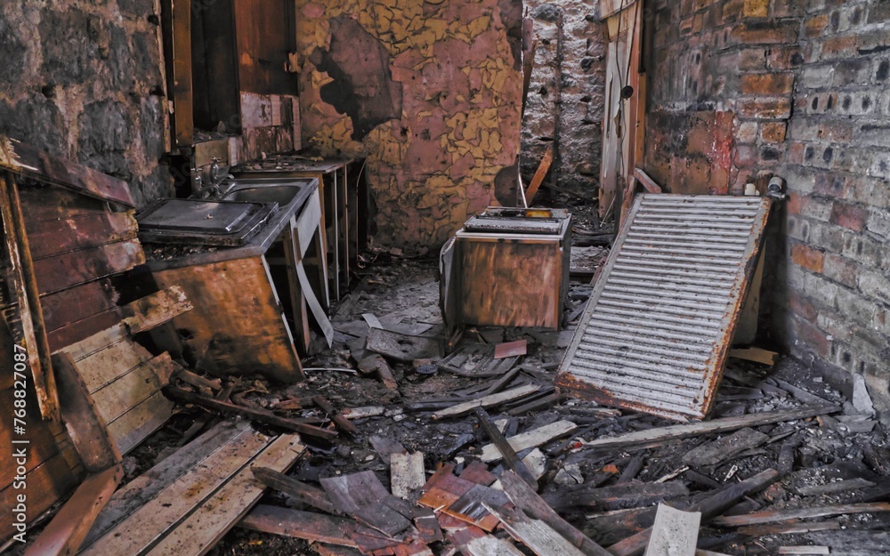 Interior view of an abandoned building kitchen with broken down walls and rusty appliances