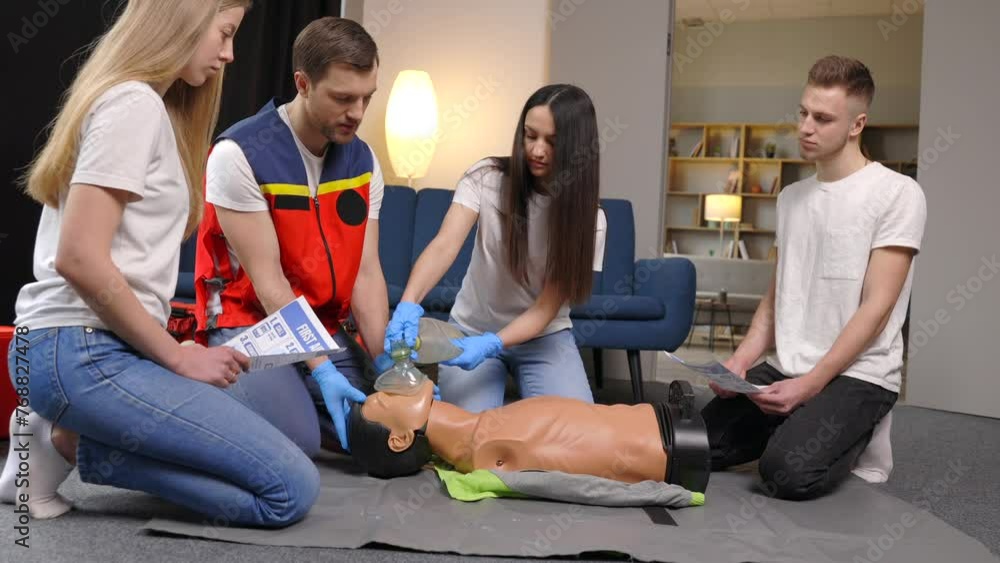 Group of people learning how to make first aid heart compressions with dummies during the training indoors Group of people learning how to make first aid heart compressions with dummies during the training indoors