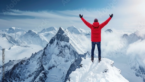 Climber in red jacket reaches the summit with arms raised, overlooking snowy mountains © Artyom