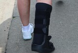Closeup of a person wearing a leg support, walking on the street