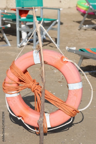 a red and white life preserver on top of a sandy beach photo