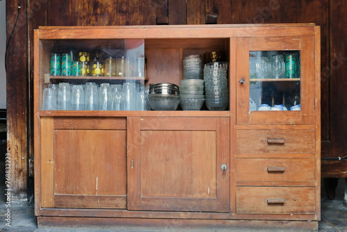 A wooden cupboard used to store glassware photo