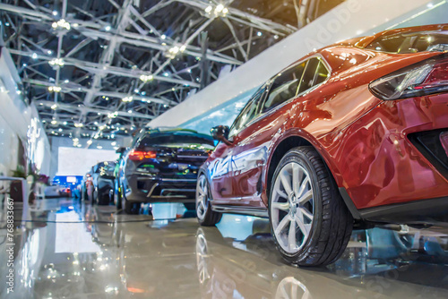 New cars display in luxury showroom with light bokeh in motor vehicle shop dealership