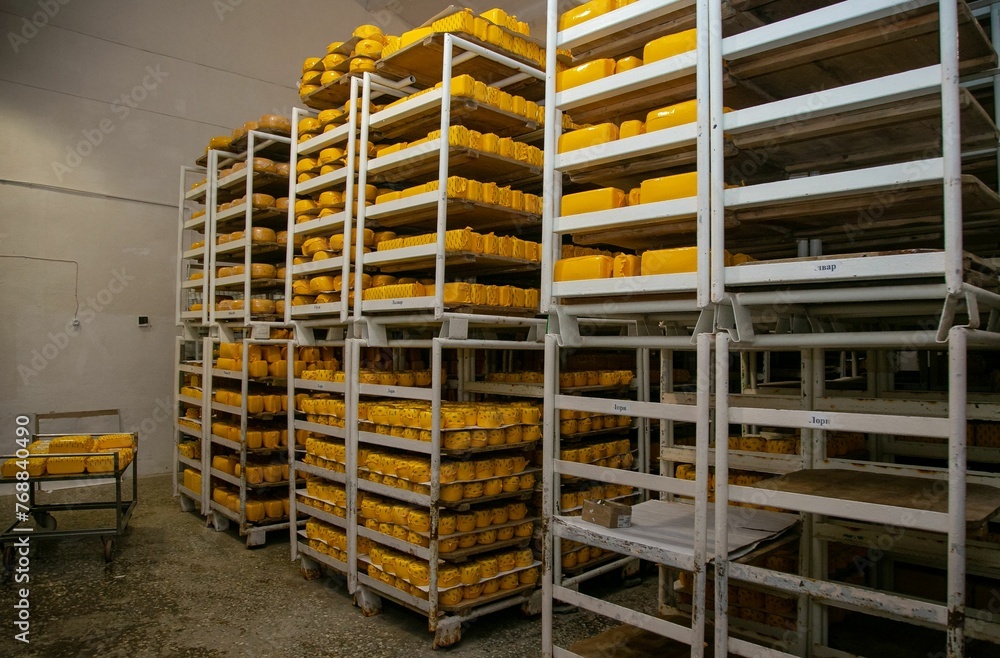 Metallic shelves of cheese in a factory