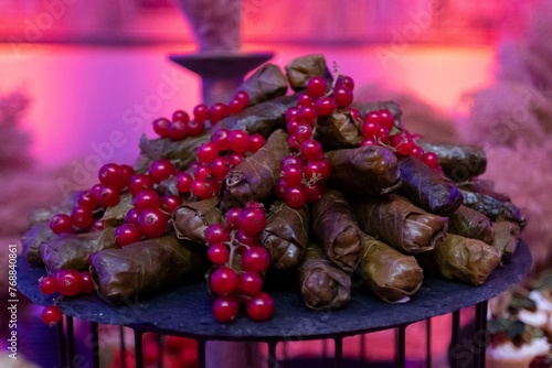 Plate with a meal featuring purple grapes as a topping: Dolma photo