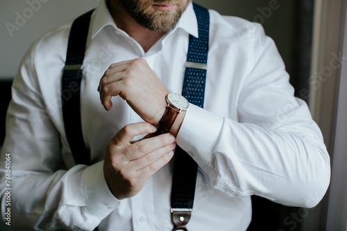 Obraz na plátně Closeup shot of a groom adjusting a wristwatch on his arm.