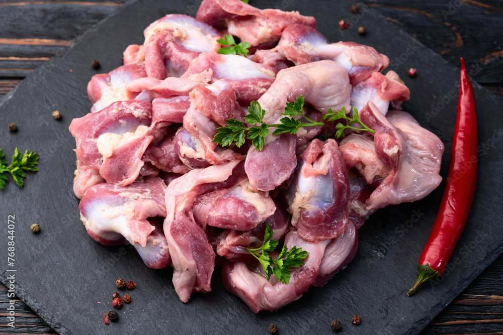 Naklejka premium Raw chicken giblets gizzard ( stomach ) , meat background