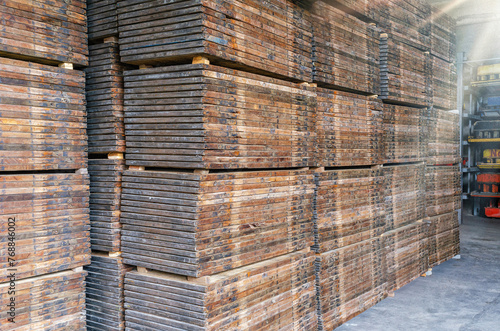 Stacks of wooden pallets. Interior of production warehouse. Plant for production of paving slabs.