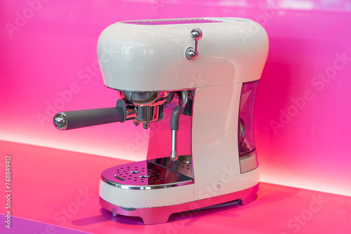 Coffee maker with vintage retro look in modern technology white color on pink kitchen background