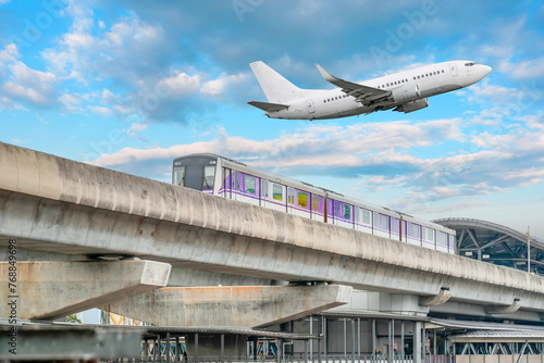 View railway track suburban subway electric train rushing departure station. Passenger plane flying in sky, take off landing at airport. Concept of modern infrastructure transport travel.
