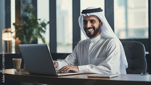 Arab businessman working on laptop computer in modern office photo
