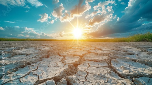cracked earth during a drought with a bright sun in the background