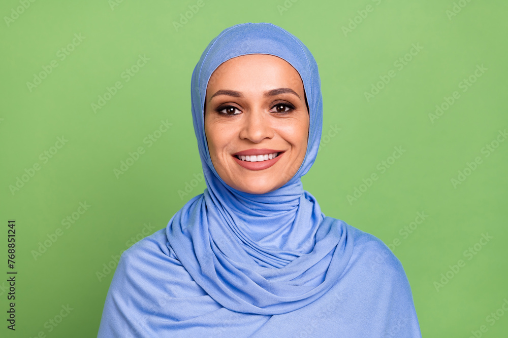 Photo of cheerful muslimah woman toothy smile cavity protection stomatology isolated over green color background Photo of cheerful muslimah woman toothy smile cavity protection stomatology isolated over green color background