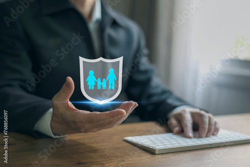 Businessman hand hold protective gesture sign of shield with group of people, family members icon inside. The concept of insurance, protection of the family, life and health insurance.