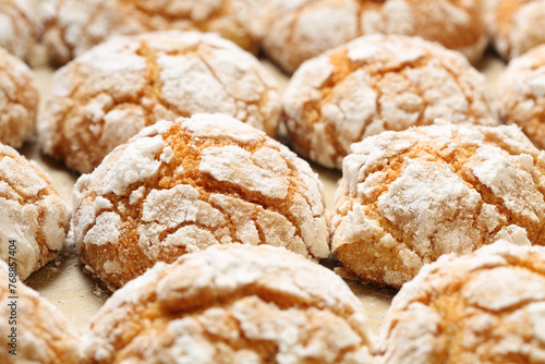 Close up of many homemade, freshly baked semolina crinkle cookies with apricot or peach jam and powdered sugar icing. Selective focus and shallow depth of field