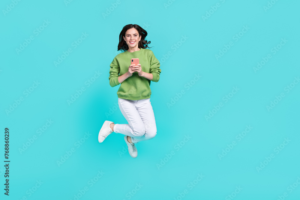 Full body portrait of pretty excited person hold telephone enjoy free time isolated on teal color background