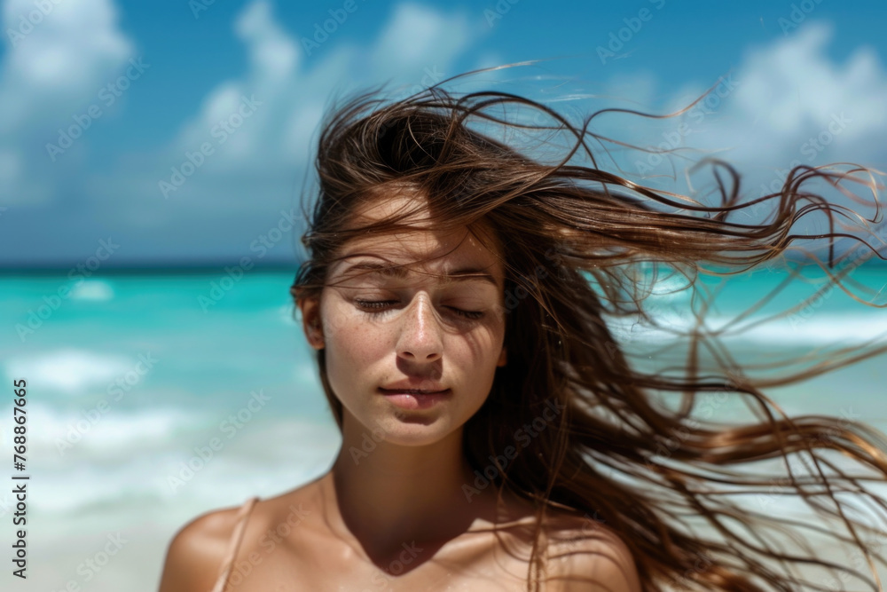 Portrait of young woman with long windy hair enjoying the breeze at beach. Beautiful girl relaxing at beach during summer holiday Portrait of young woman with long windy hair enjoying the breeze at beach. Beautiful girl relaxing at beach during summer holiday