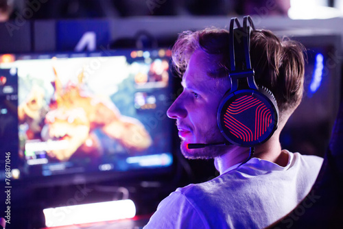 Fotografi Closeup bristly adult gamer in headset plays video game on PC at computer club cyber sport tournament
