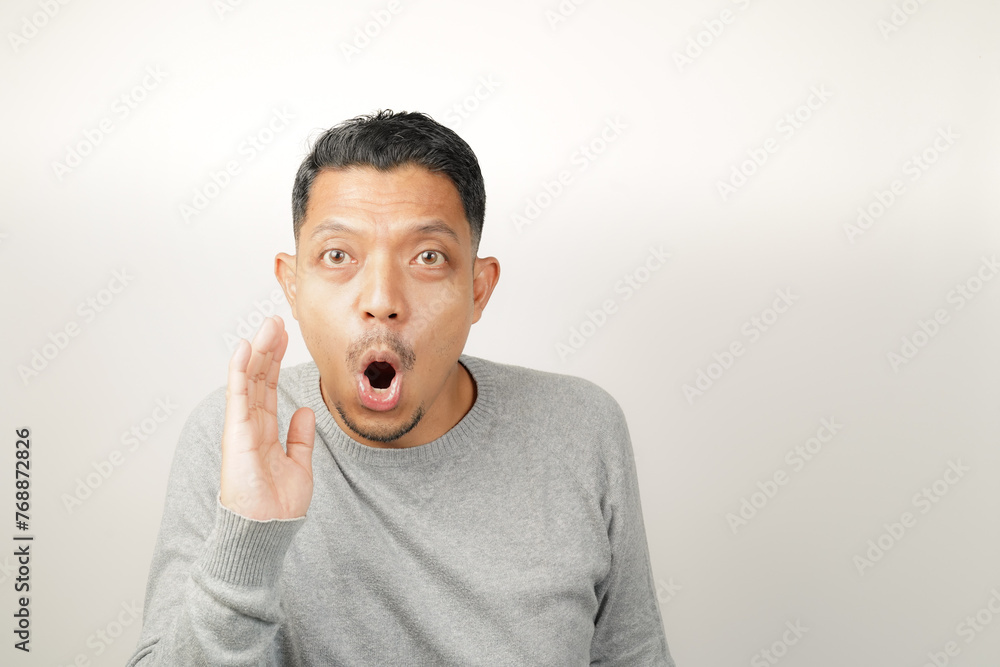 Funny Asian man is whispering some secret gossip, expression give news isolated