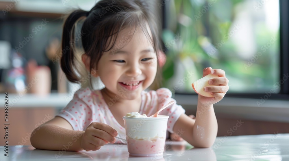 A girl happily dipping a slice of apple into a cup of yogurt, highlighting healthy snack choices A girl happily dipping a slice of apple into a cup of yogurt, highlighting healthy snack choices