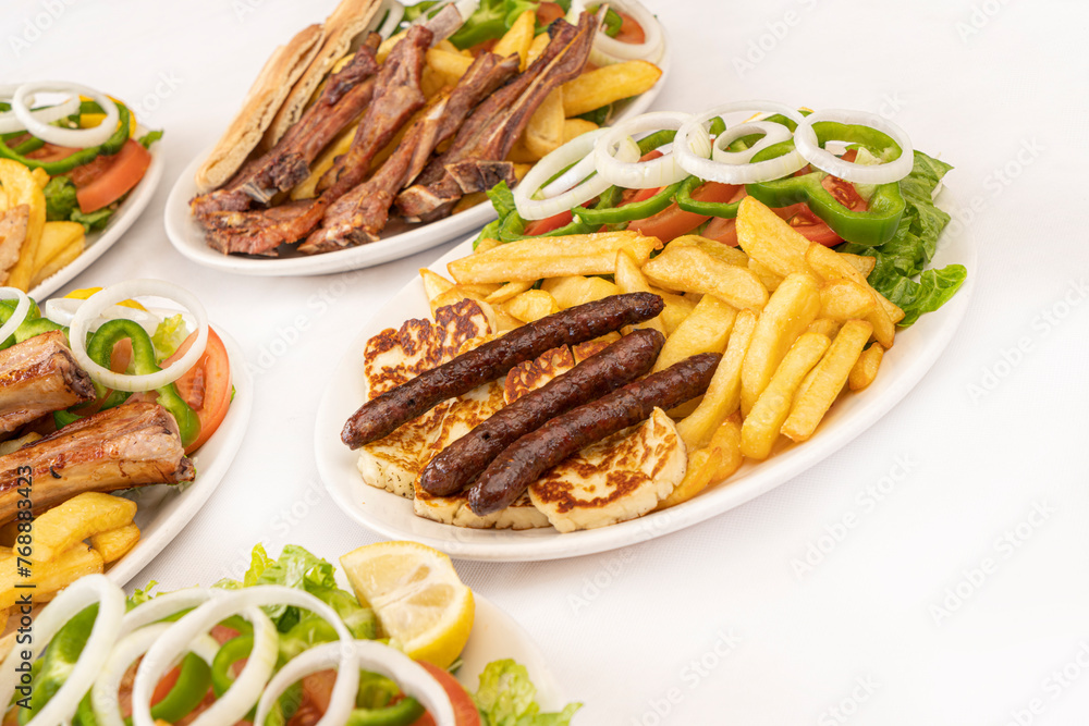 grilled sausages and halloumi with french fries and salad