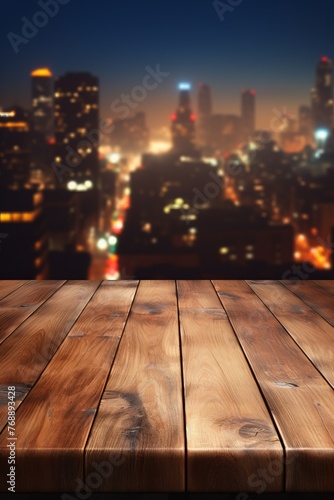 Empty wooden table with blurred city lights in the background