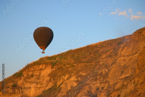 hot air balloon shadow on the side of a hill with dawns first light