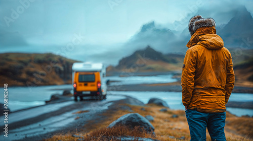Camper driver next to his parked vehicle looks at the Icelandic landscape