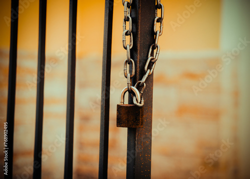 A lock is attached to a chain, which is mounted on a metal gate. This is private property.