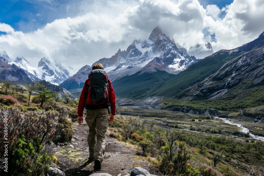 A hiker embarking on a trek through rugged mountain terrain under a dramatic sky A hiker embarking on a trek through rugged mountain terrain under a dramatic sky