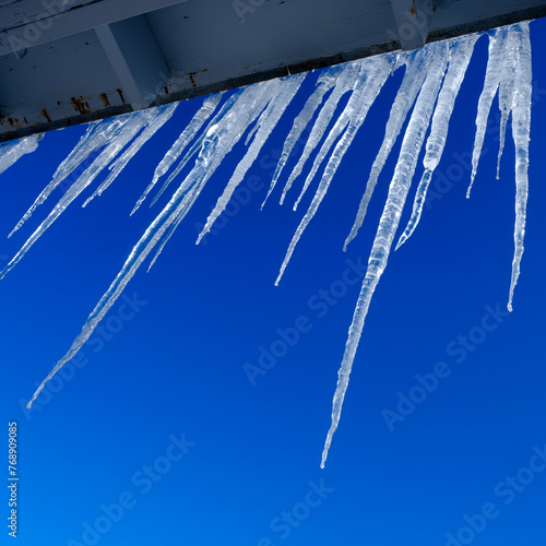 Icicles Hanging from Roof in Winter Blue Sky