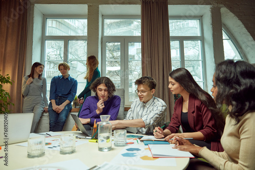 Young boys and girls, student meeting in university library for studying and doing projects together. Concept of education, youth, knowledge, homework, exams, projects. © master1305