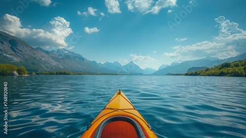 A kayak and paddle on a serene lake with mountains in the distance