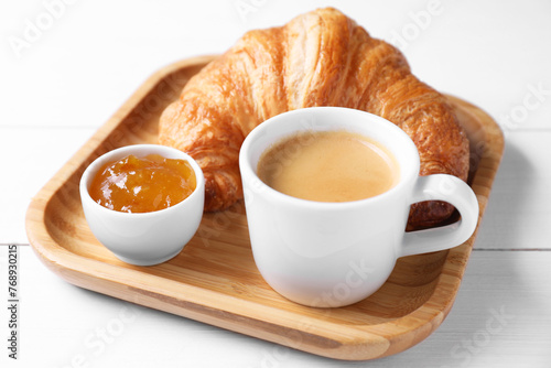Fototapeta Naklejka Na Ścianę i Meble -  Fresh croissant, jam and coffee on white wooden table, closeup. Tasty breakfast