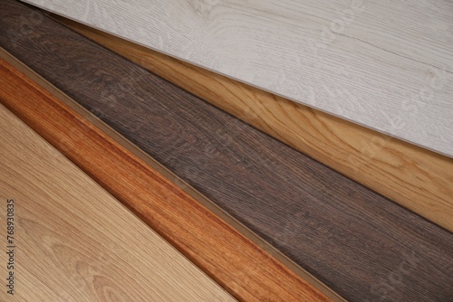 Different samples of wooden flooring as background, closeup