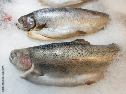 gutted chilled trout carcasses lie on small ice cubes