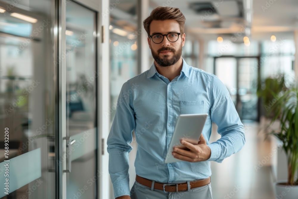 Man in dress shirt holding tablet in hallway with building fixture Man in dress shirt holding tablet in hallway with building fixture