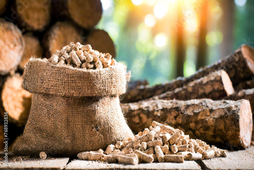 Wood pellets in a jute sack and logs photo