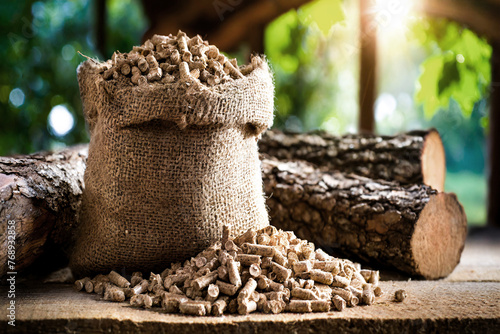 Wood pellets in a jute sack and logs photo
