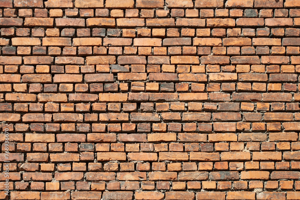 Background of old weathered brown brick wall