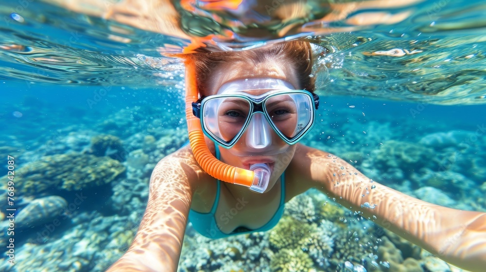 Naklejka premium Solitary island woman snorkeling alone in crystal clear waters with diving mask