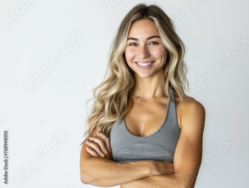Athletic blonde woman with wavy hair in sportswear smiling on a white background. Fashion and beauty. Sports, active lifestyle, motivation, weight loss and fat burning, nutrition and training program. © Restyler