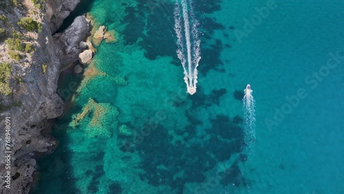 Directly above - Two boats driving in opposite directions near the coast line of Sardinia, Italy. photo