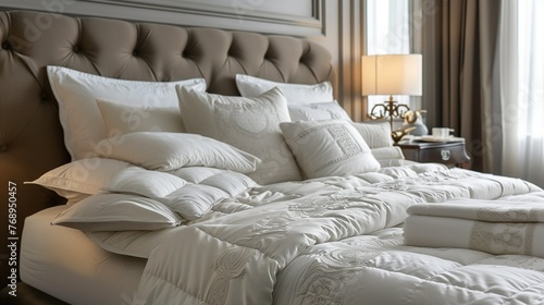 Luxurious bed with  luxurious set of bedding including pillowcases, duvet cover , all in white photo