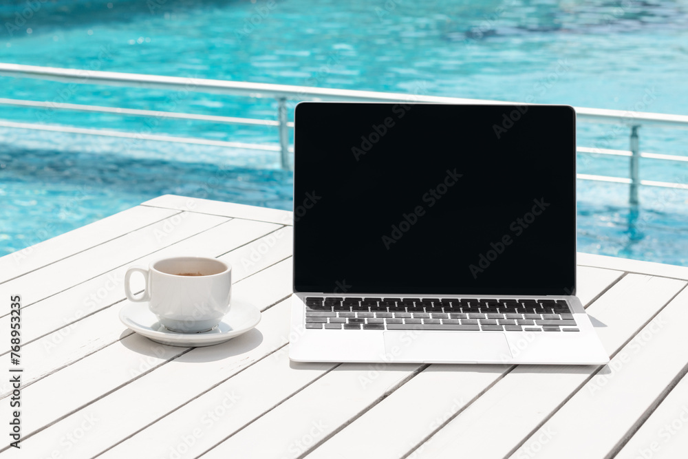 Laptop computer with black blank screen and coffee cup on table desk on ...