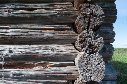 Corner of old weathered log cabin. Texture of cracked rotten log wall