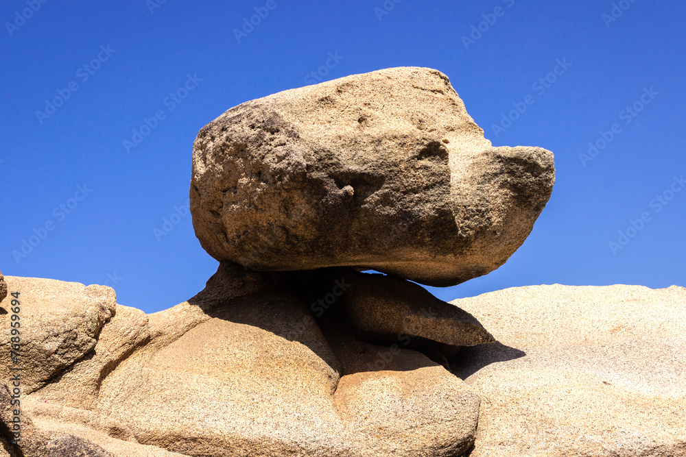Very large rock in harmonious balance under a blue sky