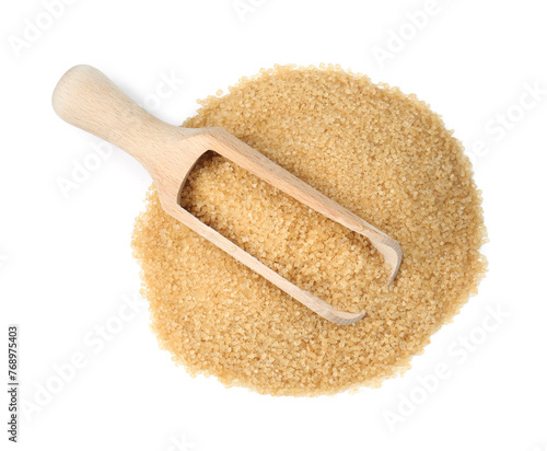 Pile of brown sugar and wooden scoop isolated on white, top view