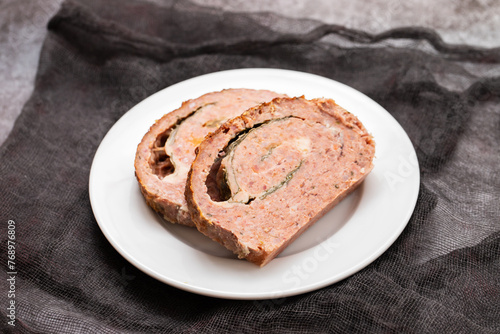Slicing classic meatloaf on a white serving plate